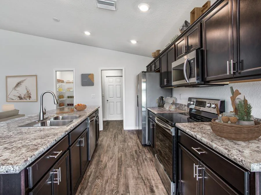 Open kitchen with counter-height island in the Parsyn new home in Haines City, FL