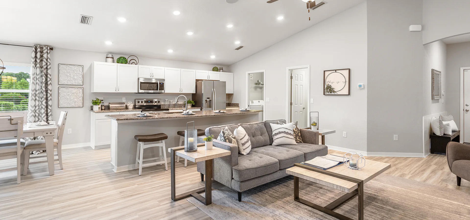 Bright and open living area with white cabinets and light colored LVP flooring