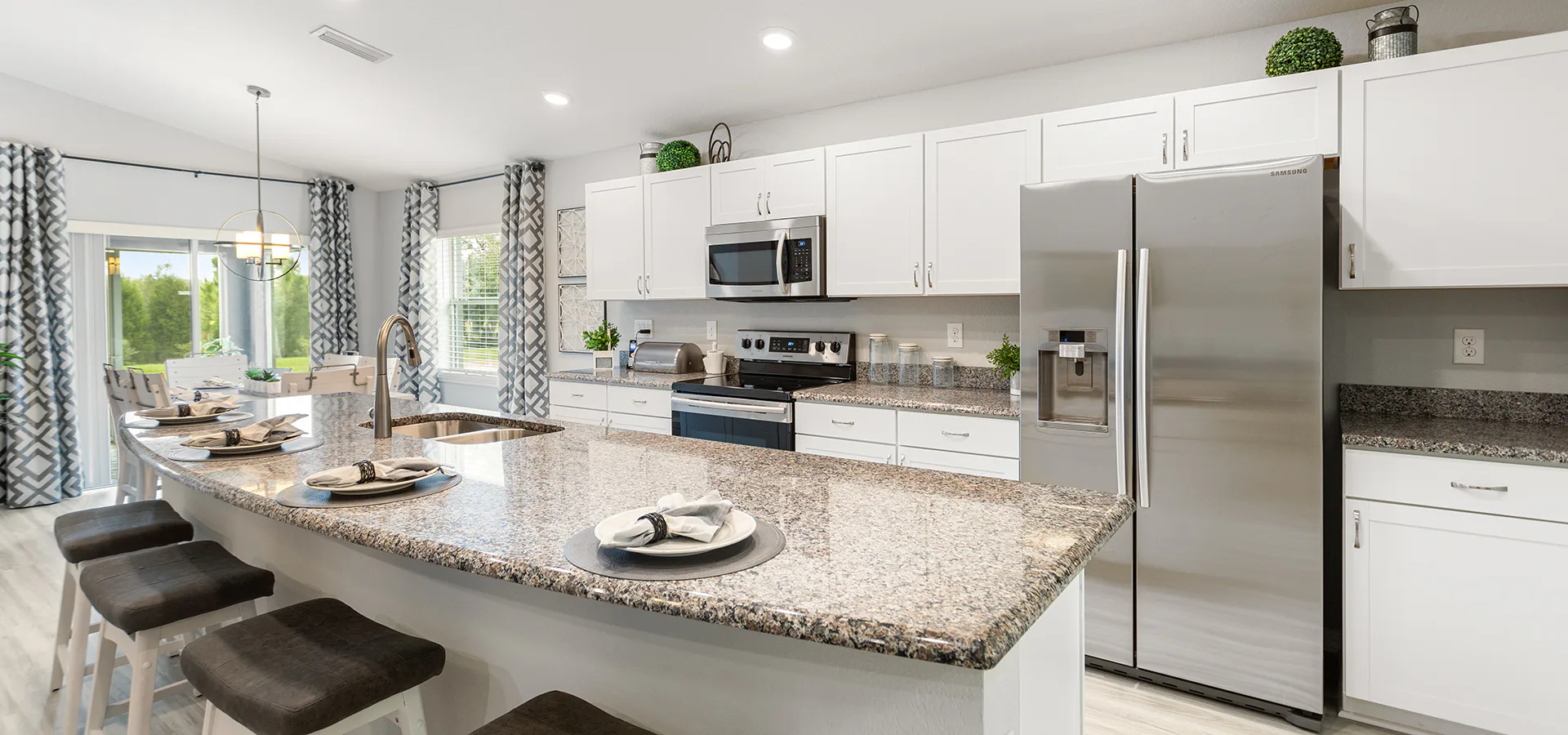 Large kitchen island with granite countertops and white cabinets