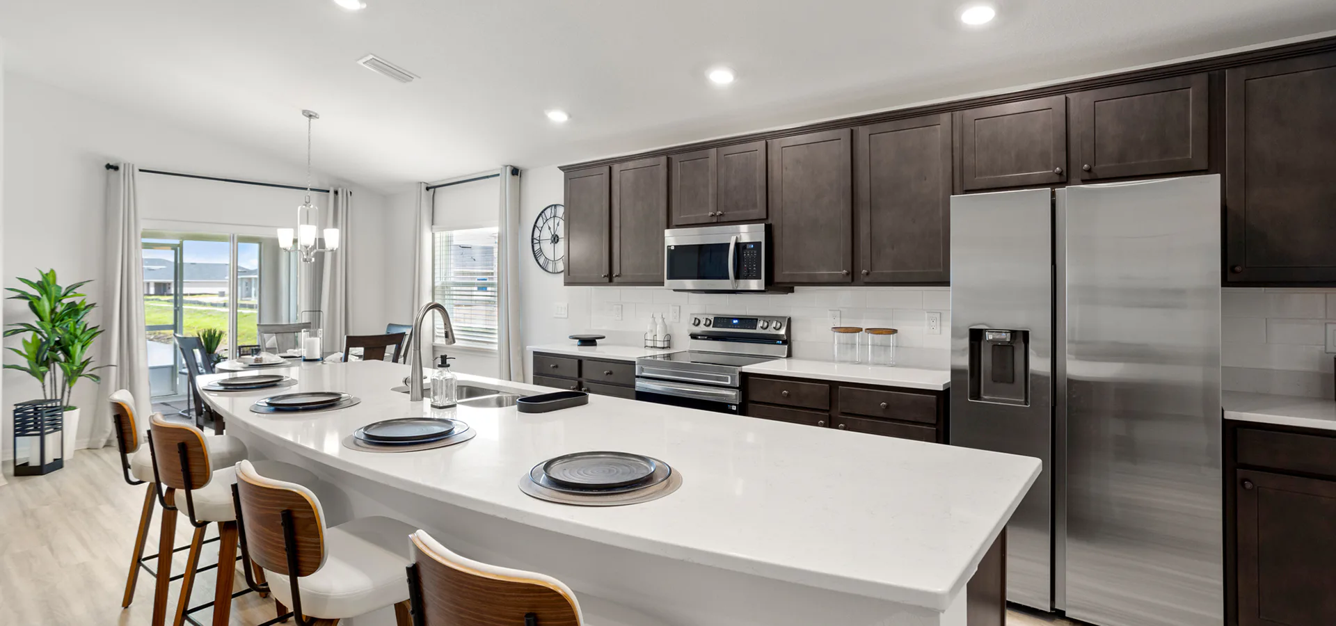 Brightly lit kitchen with wood cabinets and white quartz in the Parker by Highland Homes