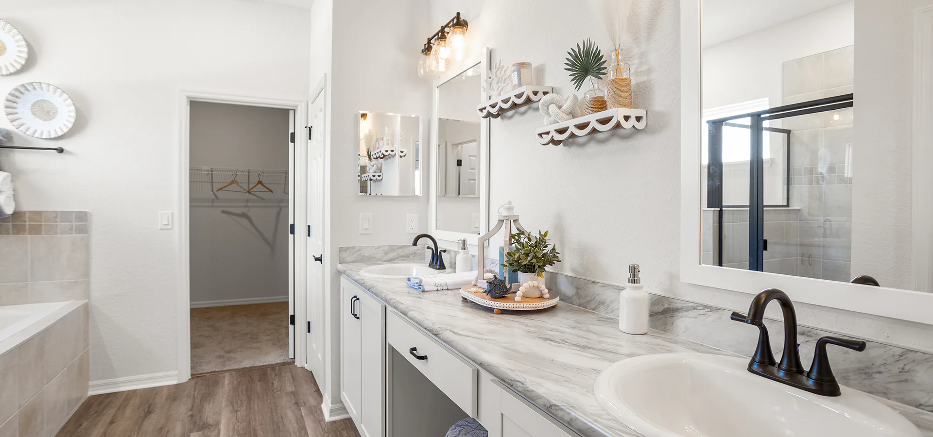 Spa-style bathroom with dual vanities, seated space, and a soaking tub.