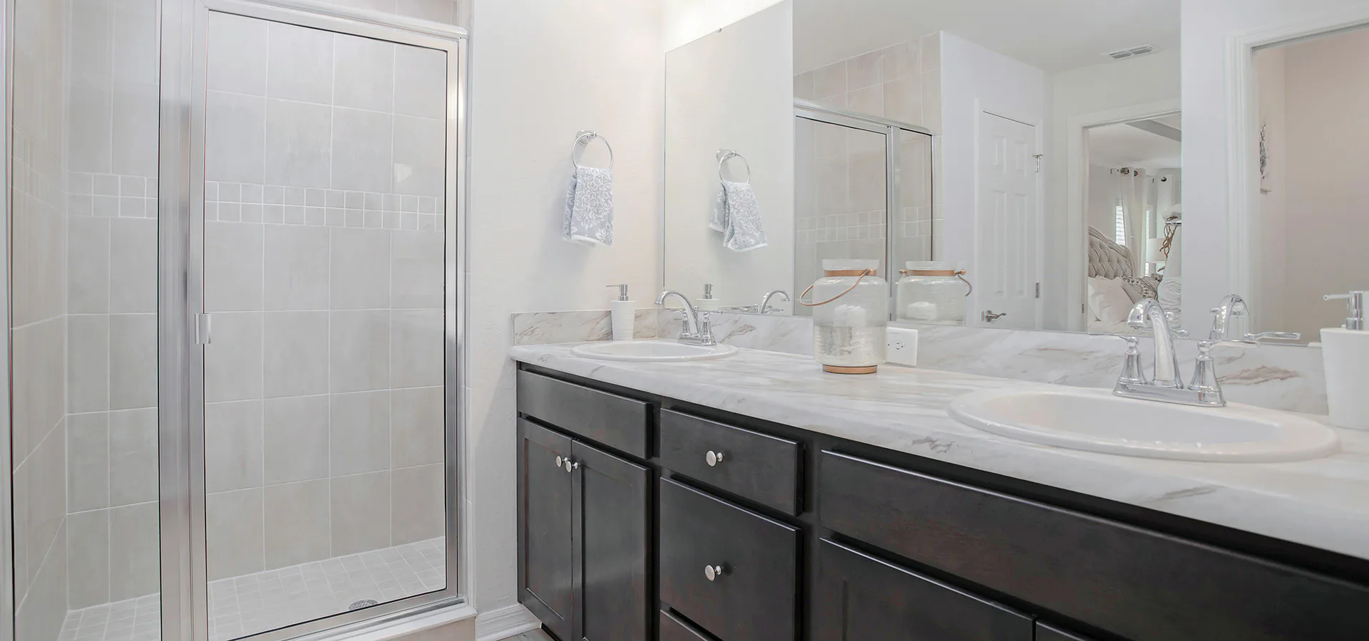 Private en-suite owner's bath with dual vanities and tiled shower in the Raychel, a new home plan by Highland Homes