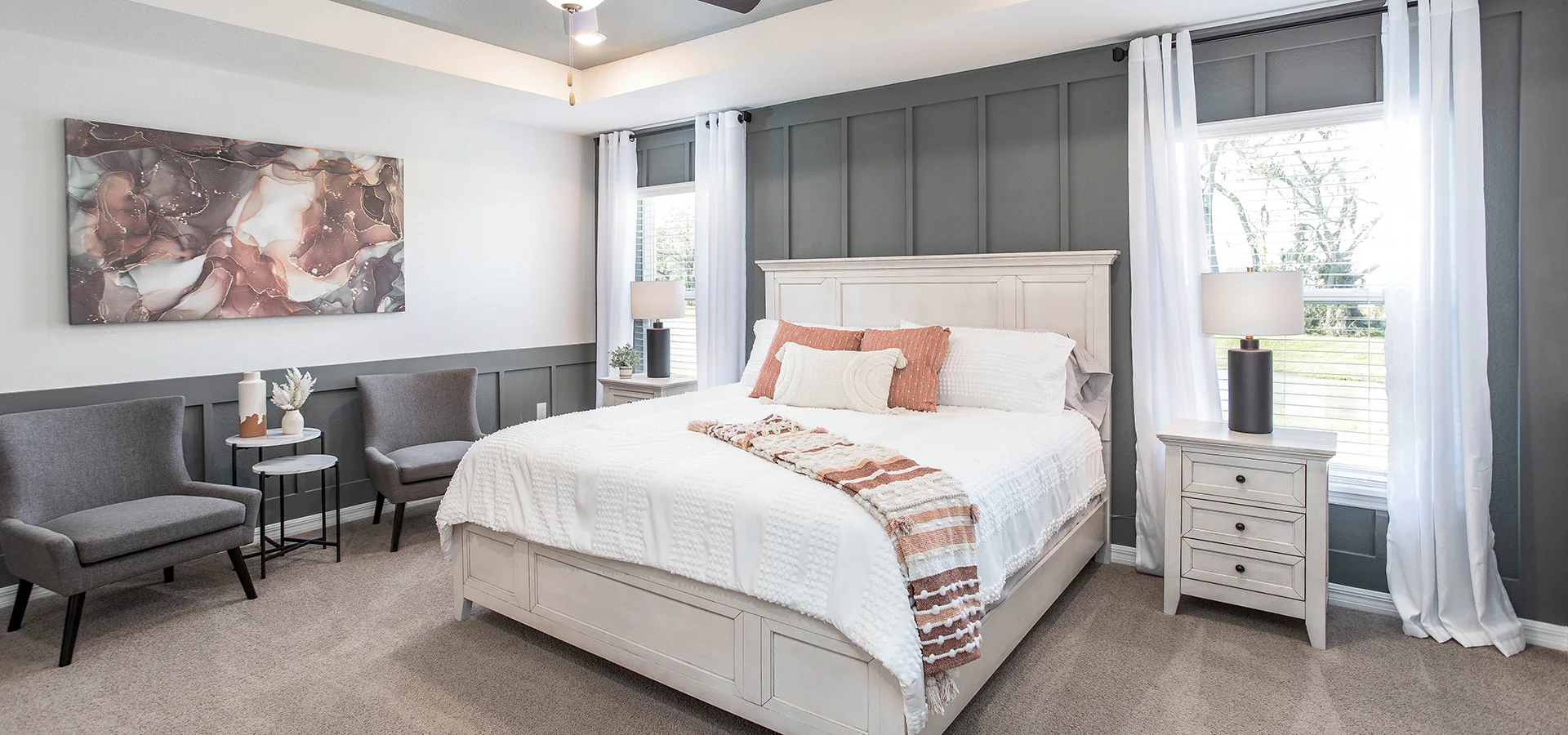 Bedroom with a gray accent wall and sitting area