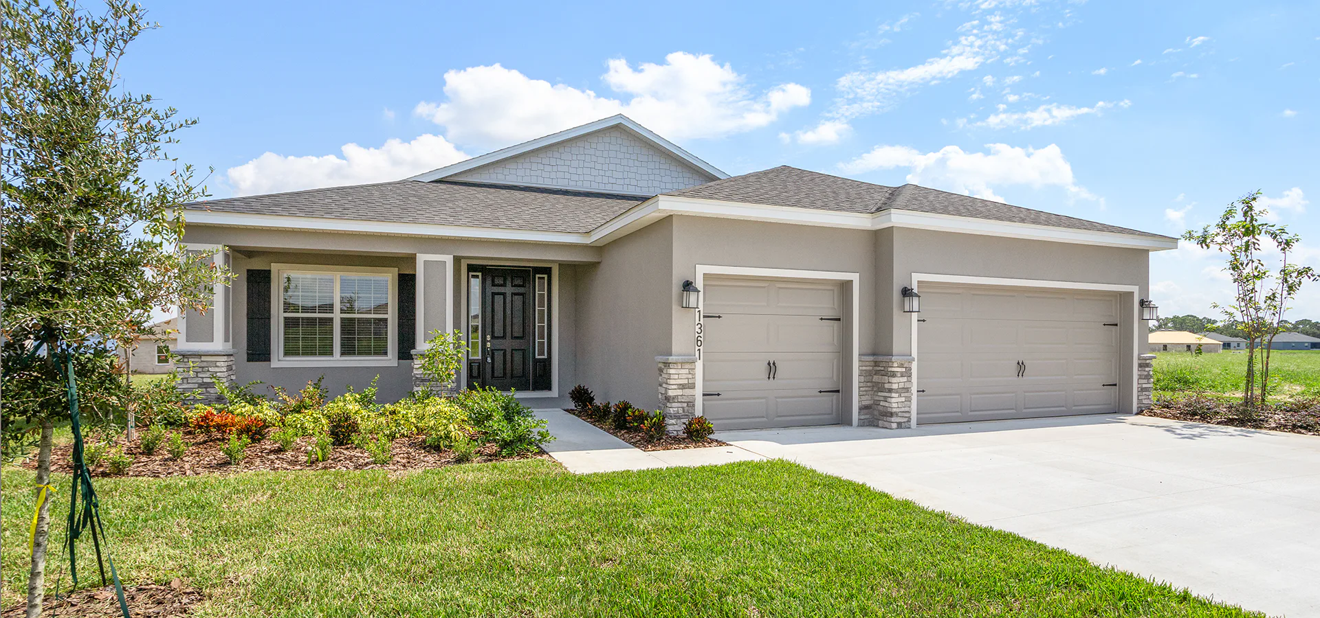 Craftsman style home exterior with a porch, stone accents, and a 3-car garage