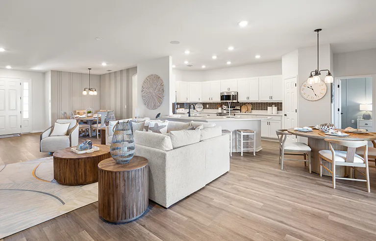 Open living area in the Westin II by Highland Homes in Tampa, decorated with mixed woods and light colors.