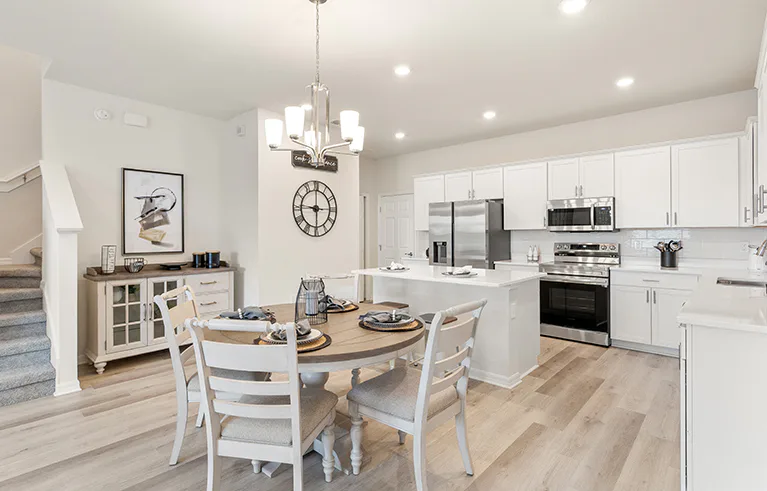 A St. Cloud, Florida, townhome kitchen with white cabinets, wood floors, and eat-in space.